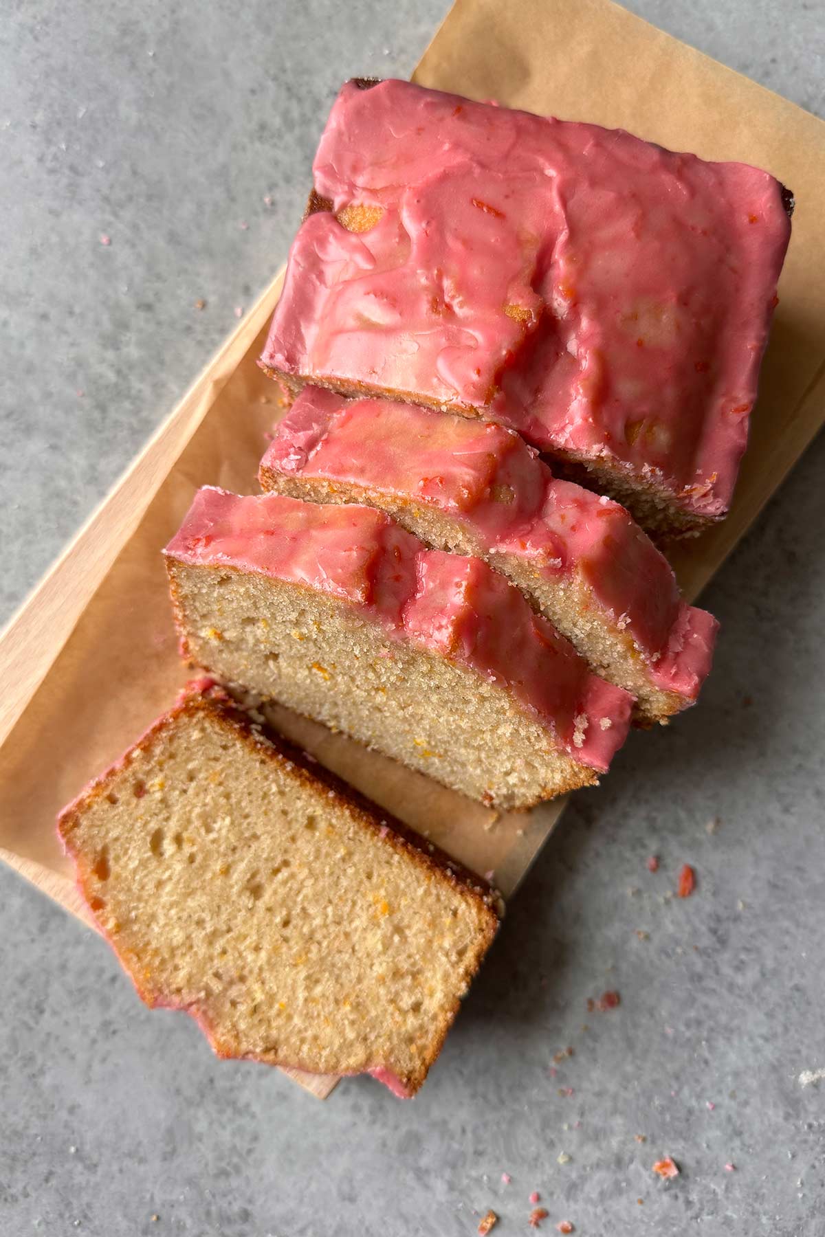 blood orange pound cake with blood orange glaze on cutting board.