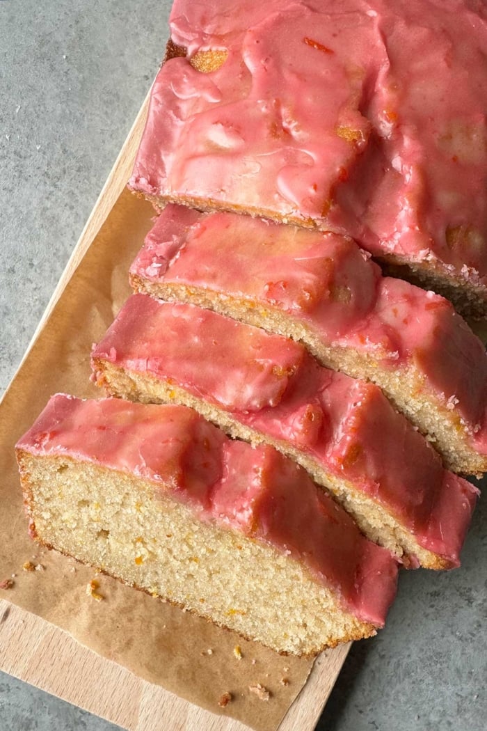 blood orange pound cake with blood orange glaze on cutting board.
