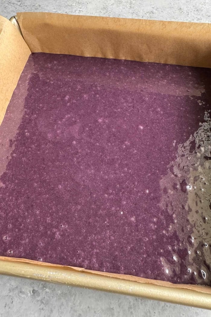 pour batter into prepared parchment lined baking pan.