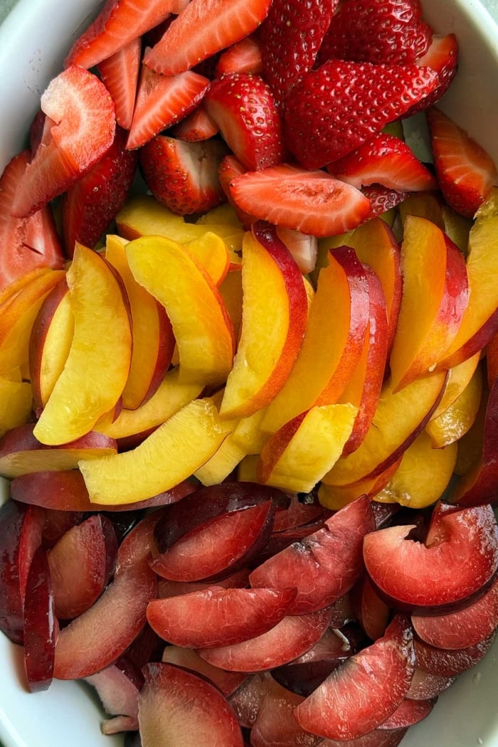 sliced strawberries, nectarines, and plums on serving tray.