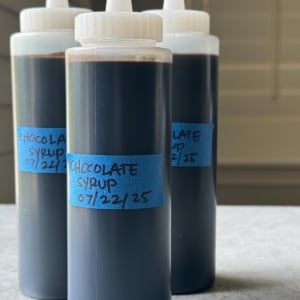 three bottles of homemade dark chocolate syrup.