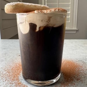 cold brew coffee topped with tiramisu foam and garnished with ladyfinger cookie.