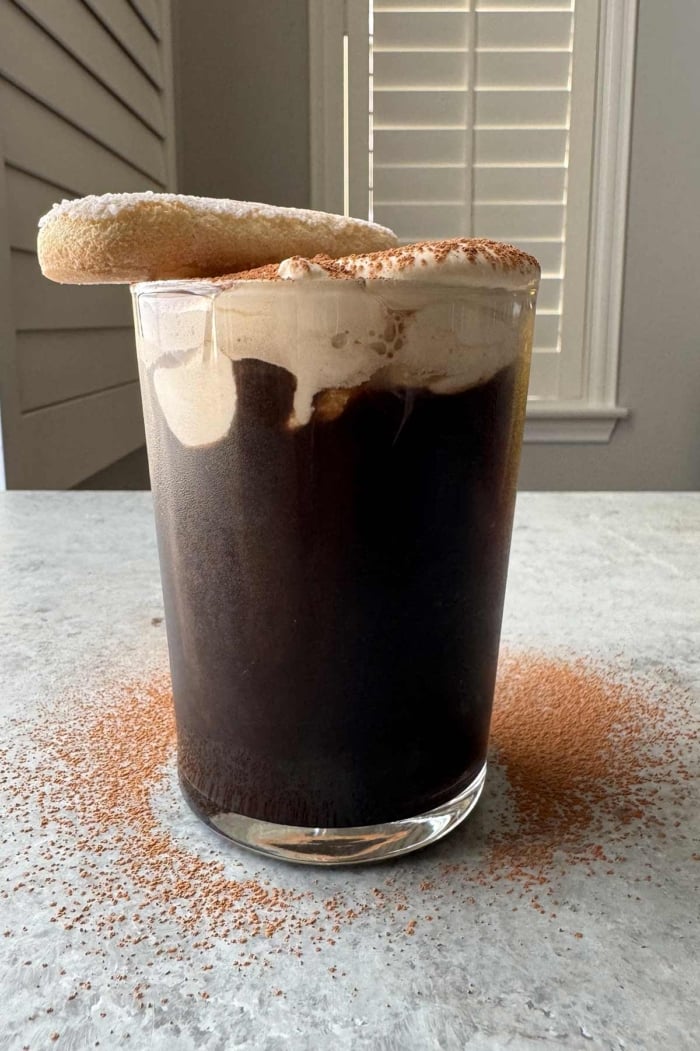 cold brew coffee topped with tiramisu foam and garnished with ladyfinger cookie. 