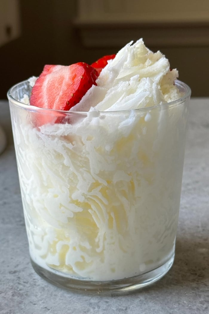 shaved milk ice in glass garnished with strawberry.
