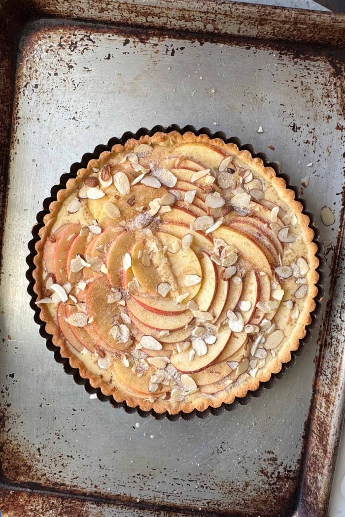 unbaked apple almond frangipane tart on baking sheet.