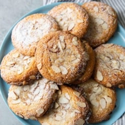 almond croissant cookies laid out on blue serving plate.