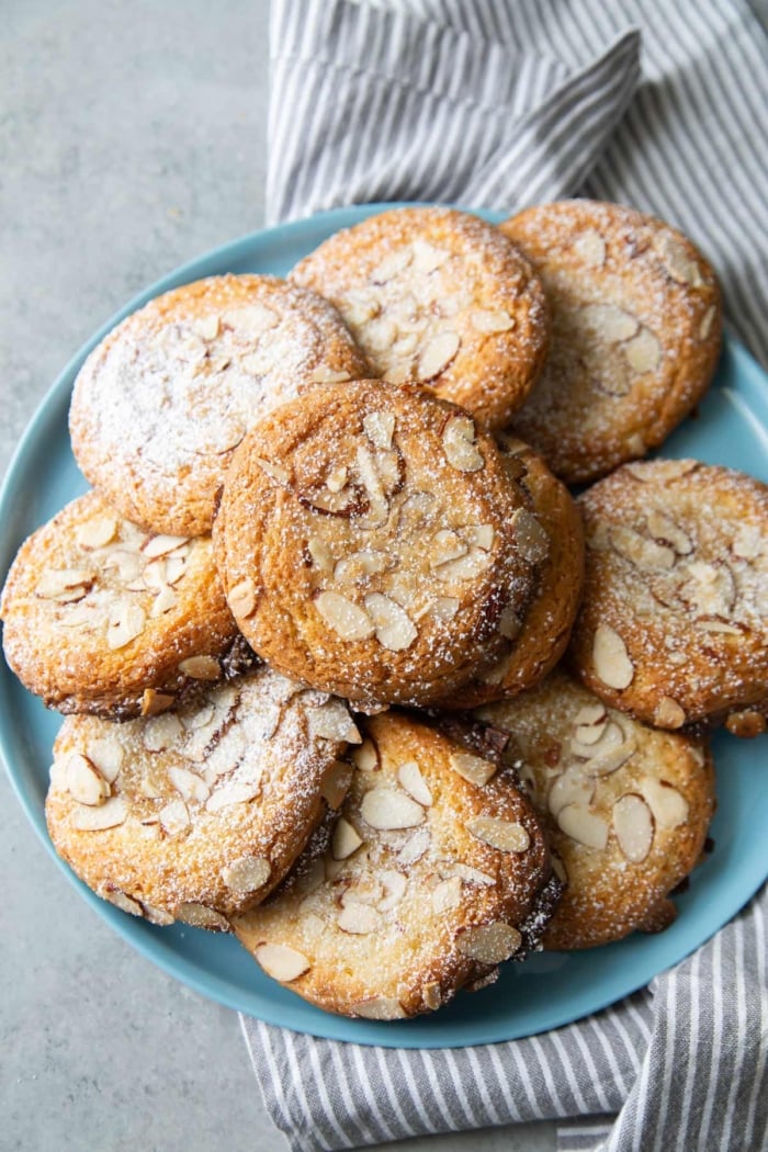 almond croissant cookies laid out on blue serving plate.