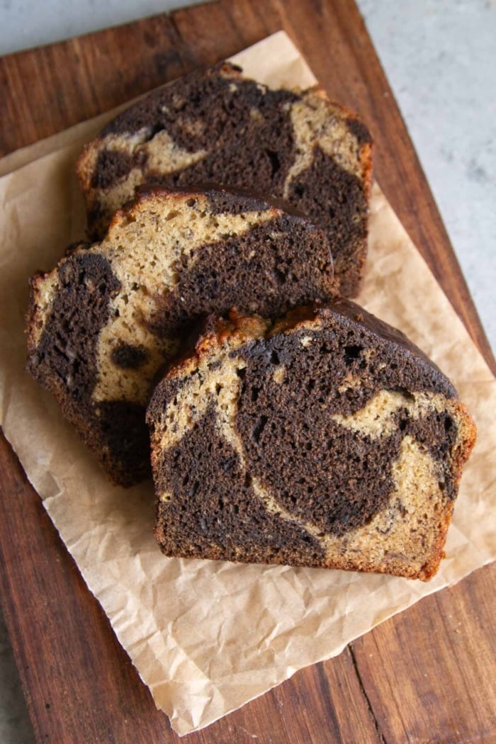 slices of marbled hojicha banana bread on parchment lined wood board.