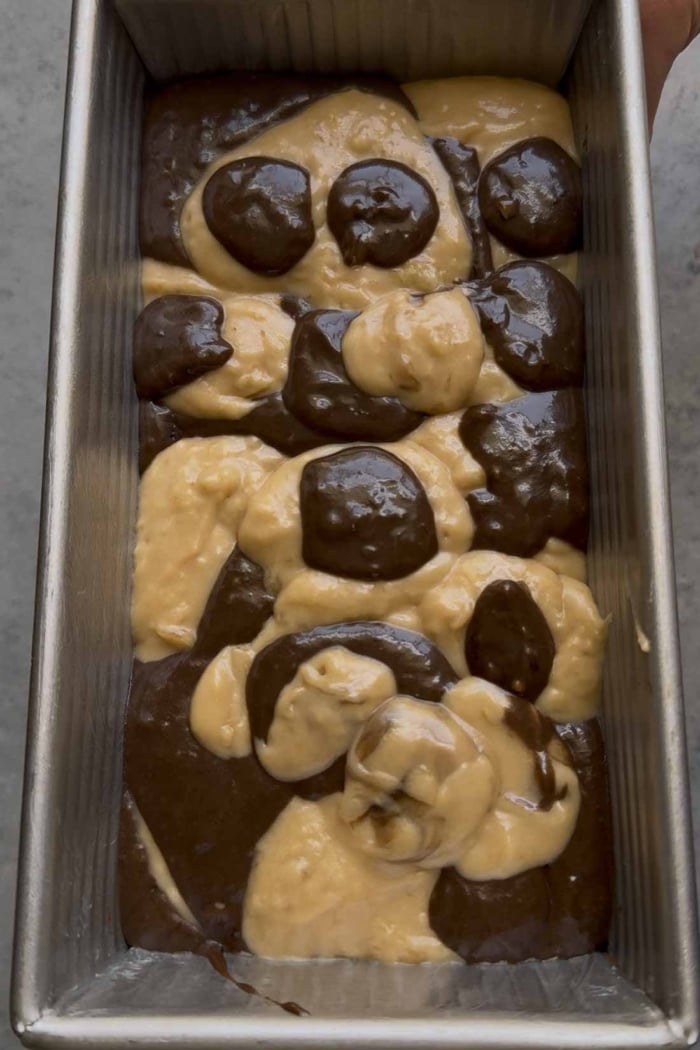 scoops of two batters in loaf pan.