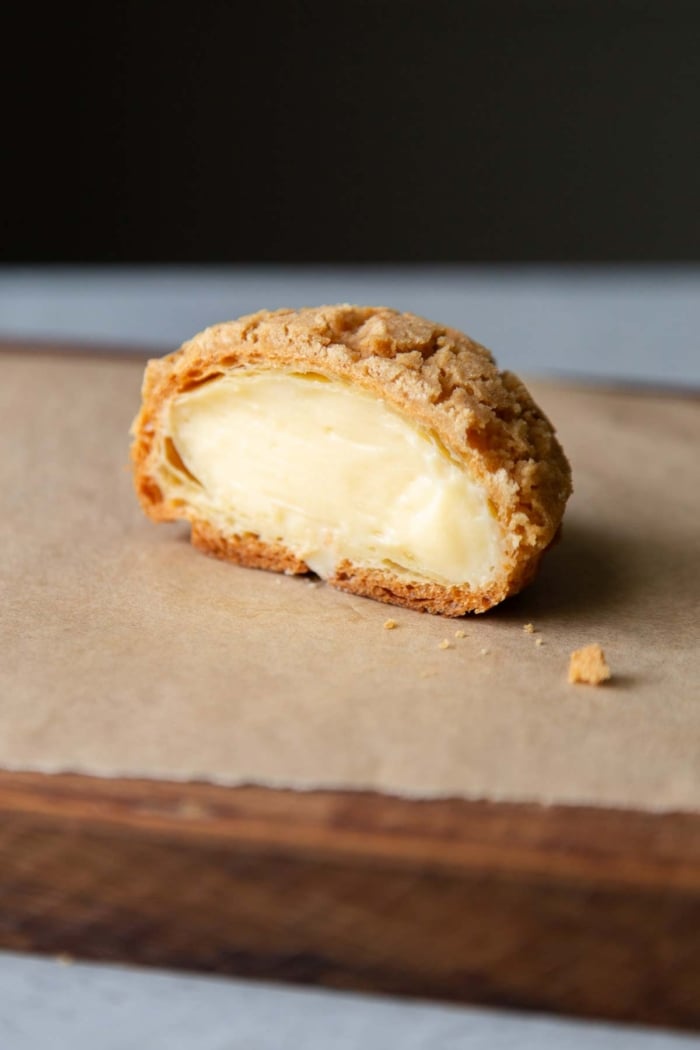 cross section of pastry cream filled choux au craquelin.