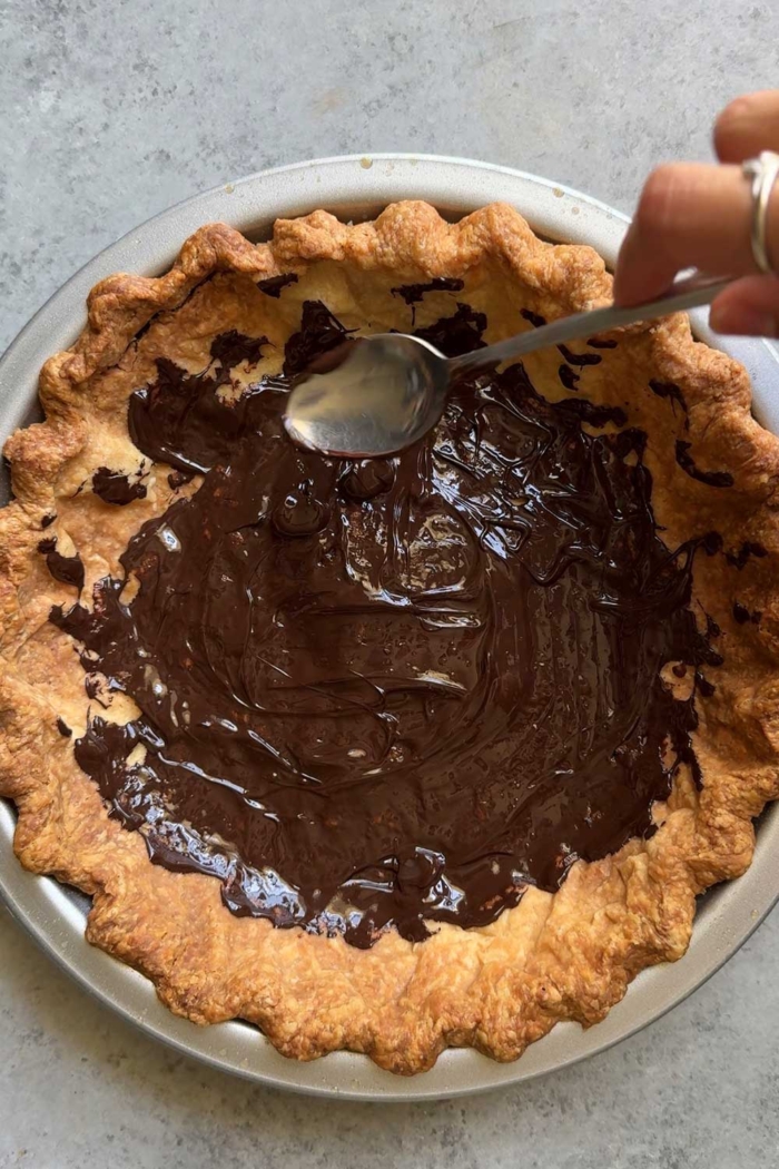 spread thin layer of melted chocolate inside baked pie shell.