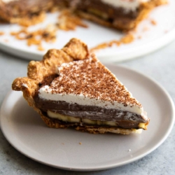 slice of banana chocolate cream pie on grey serving plate.