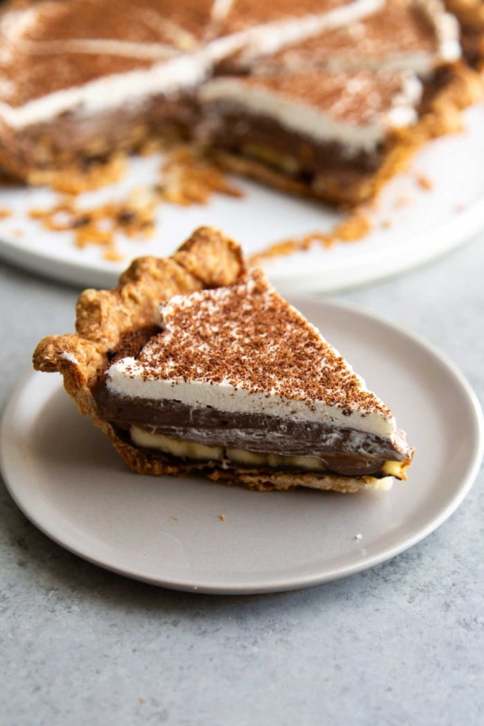 slice of banana chocolate cream pie on grey serving plate.
