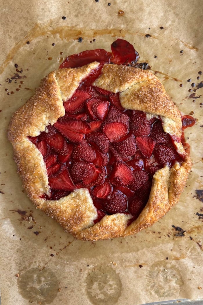 baked strawberry galette on parchment paper.
