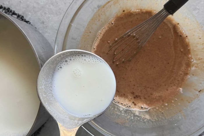 slowly ladle small amounts of hot milk into egg mixture.