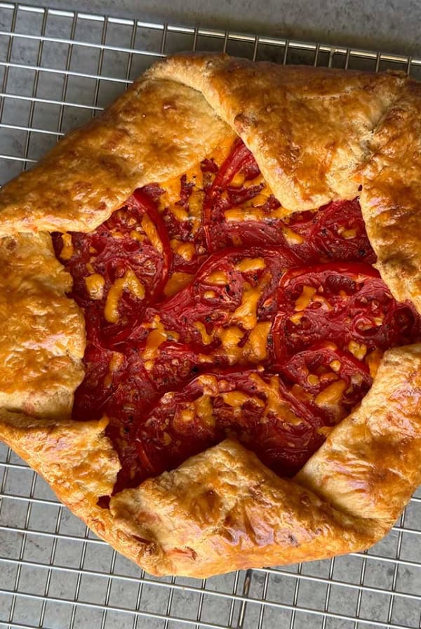 fresh baked cheddar tomato galette on wire rack.