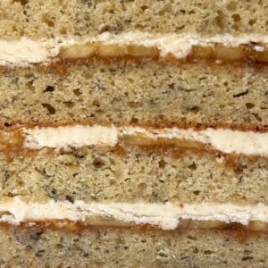 close up interior of banana cake showing brown butter frosting, peanut butter layer, and sliced bananas.