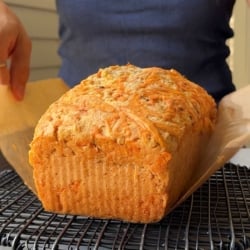 cheddar beer bread placed on black cooling rack.