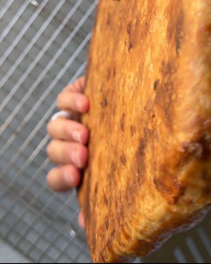 hand holding baked galette to show underside of cooked dough crust.