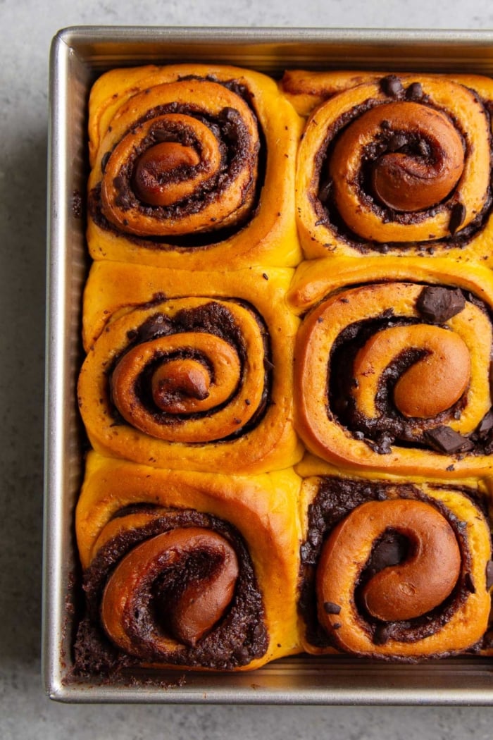 close up six unfrosted pumpkin rolls filled with chocolate and cinnamon.