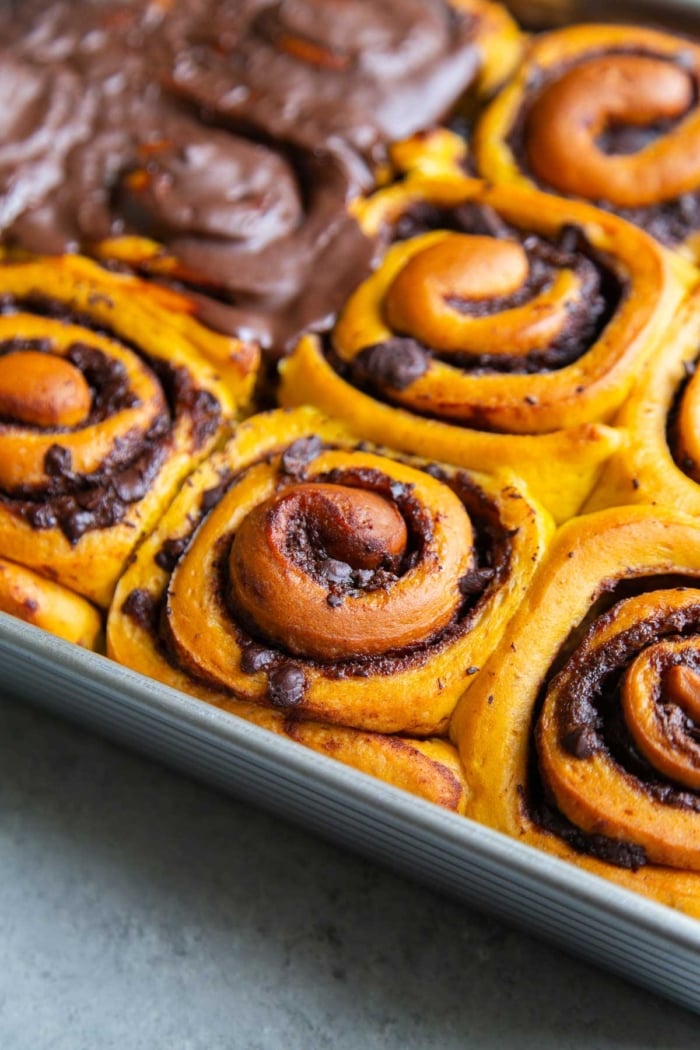 close up of chocolate filled pumpkin rolls in baking pan.