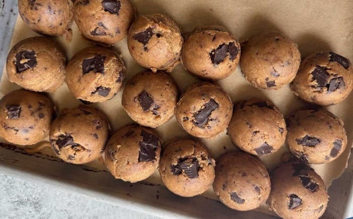 portioned out cookie dough on parchment line baking sheet.