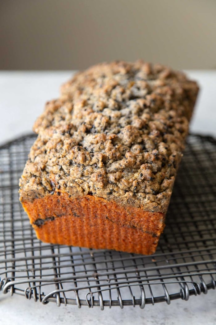 black sesame crumb pumpkin cake on black wire rack.
