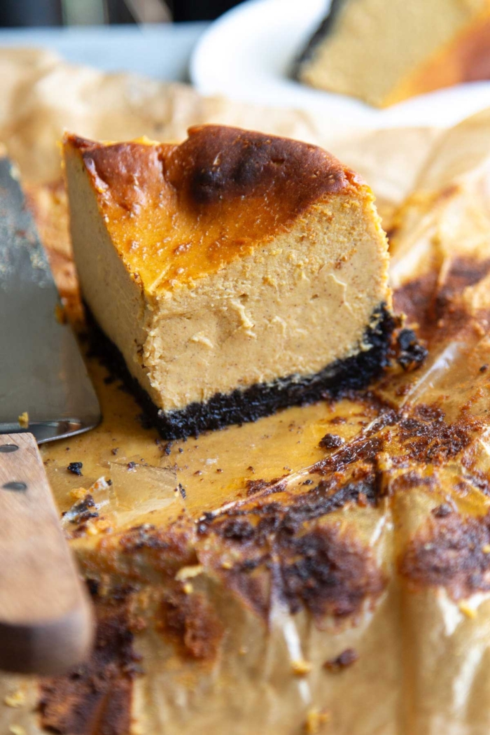 oreo crusted pumpkin Basque cheesecake on parchment paper.
